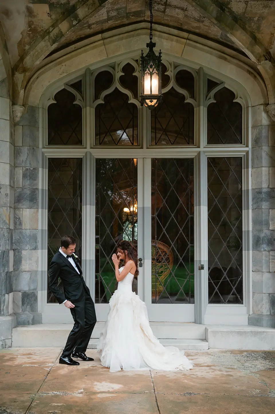 The couple beneath the carved stone arch of a Gothic doorway at the mansion.