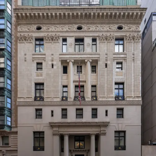 The limestone and brick façade of the Harmonie Club at 4 East 60th Street, its tall arched windows and balconies rising above the street.