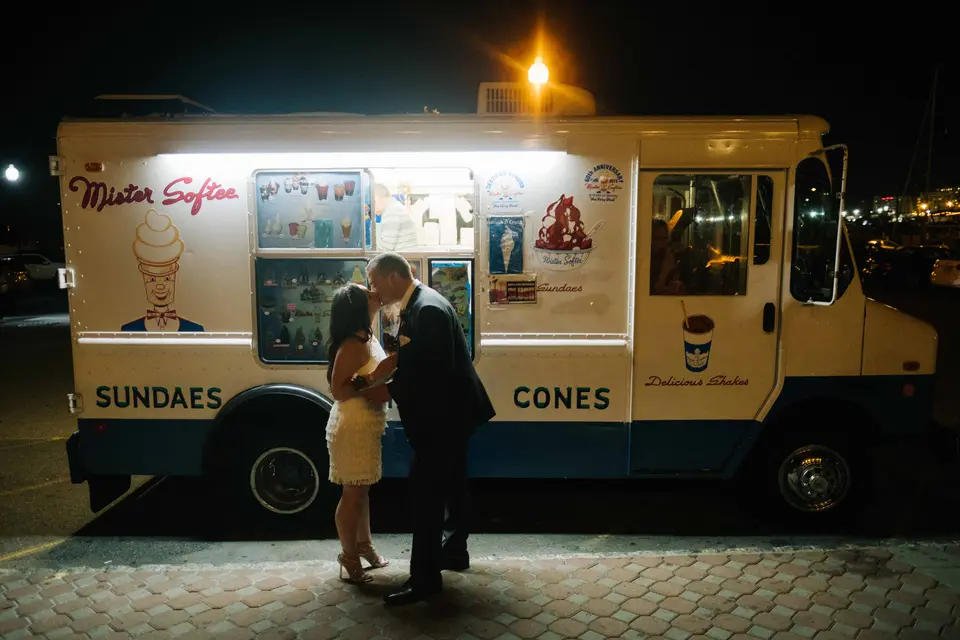 Late at night, the couple kiss in front of a lit ice cream truck parked outside.