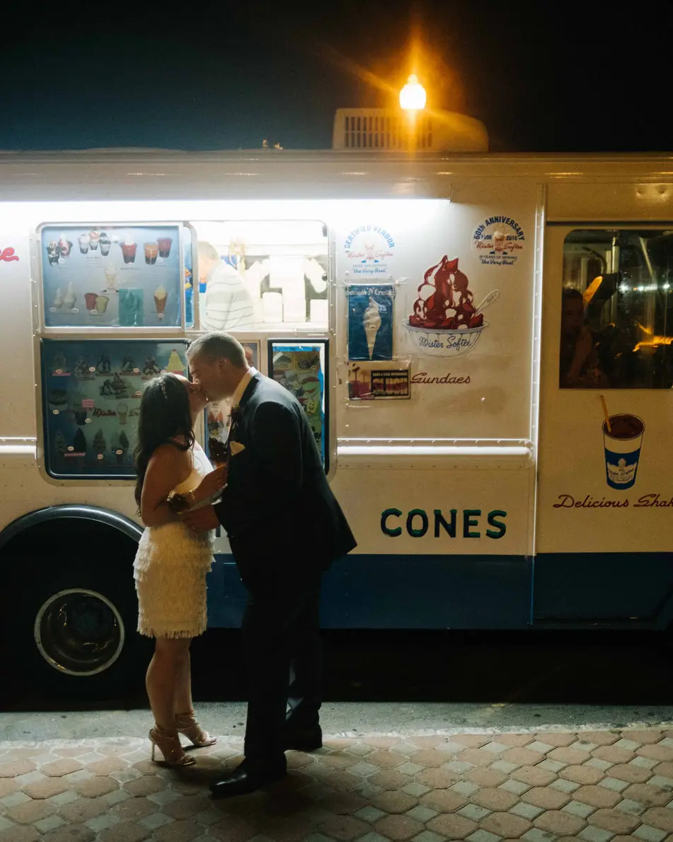 Late at night, the couple kiss in front of a lit ice cream truck parked outside.