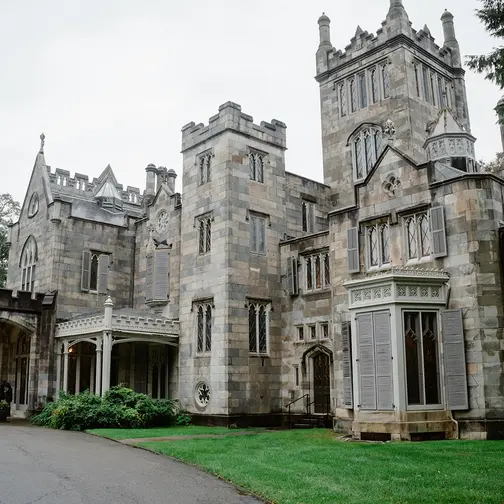 Lyndhurst Mansion's grey stone towers and turrets above the lawn.