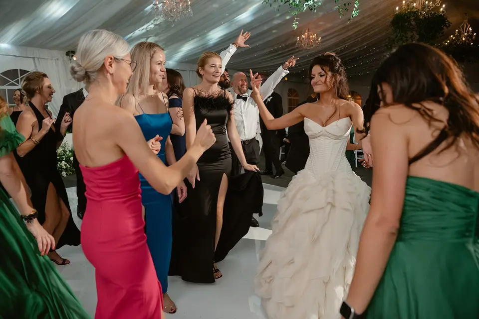 The bride dances with guests in jewel-colored dresses.