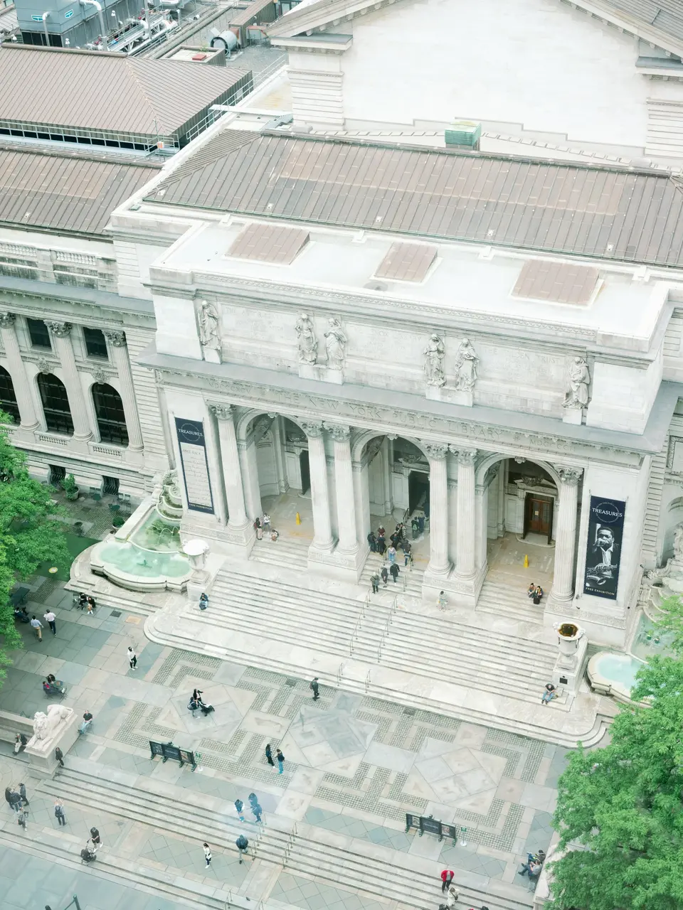 The New York Public Library on Fifth Avenue seen from high above, its marble steps and fountains below.