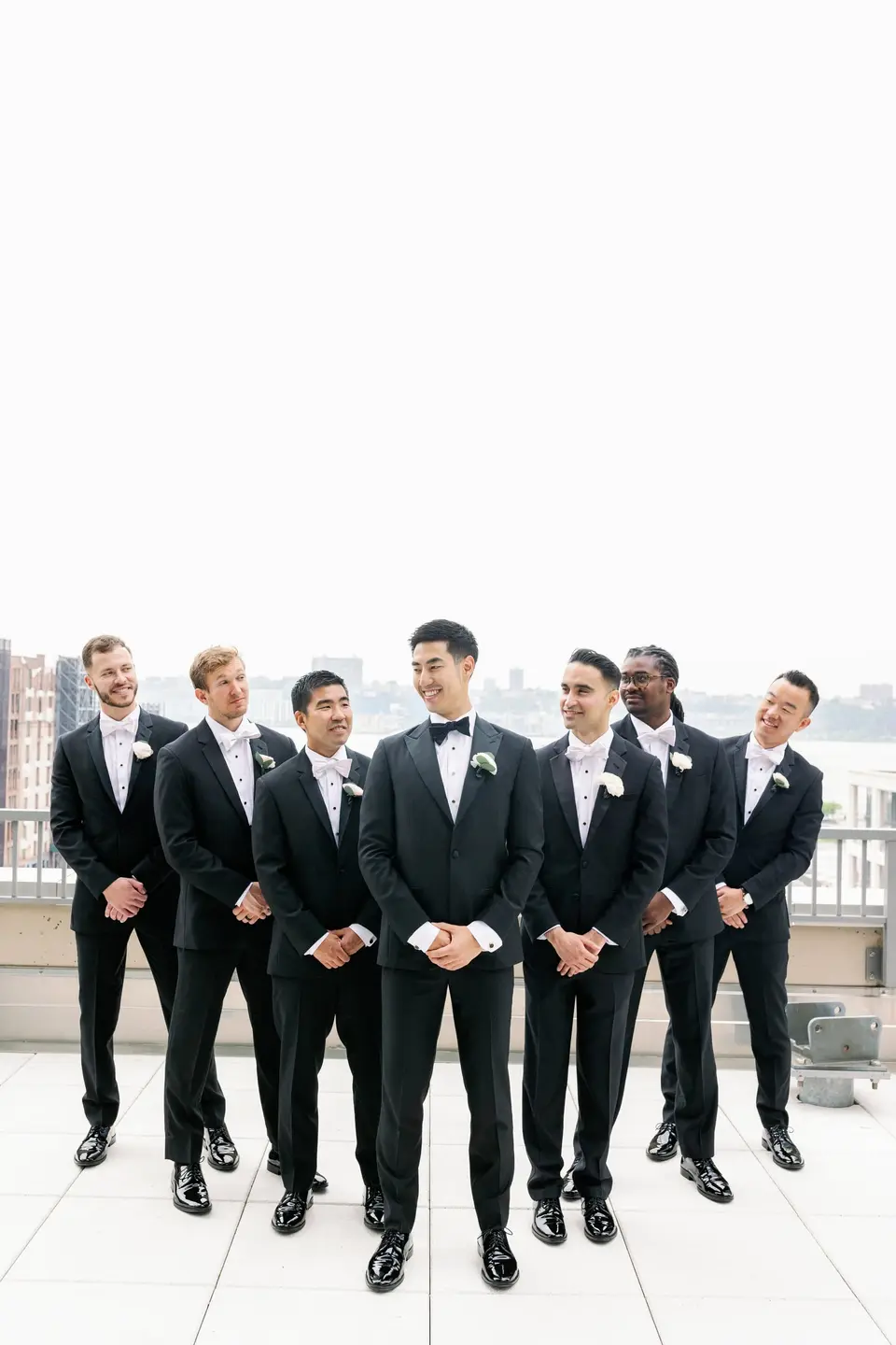 The groom and his groomsmen on a rooftop terrace, the Hudson behind them.
