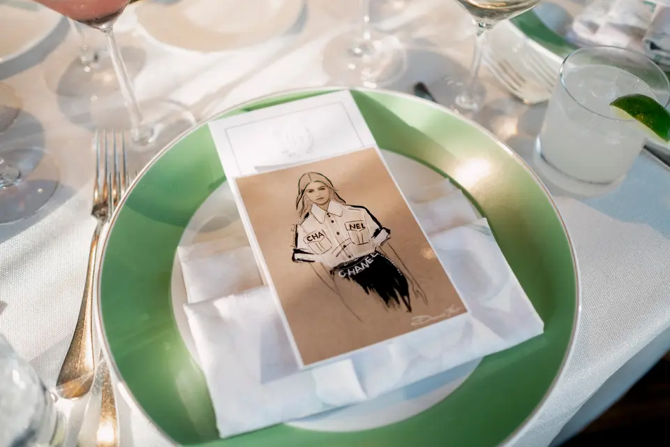On a green charger, a place card carries a small illustrated portrait of the guest.