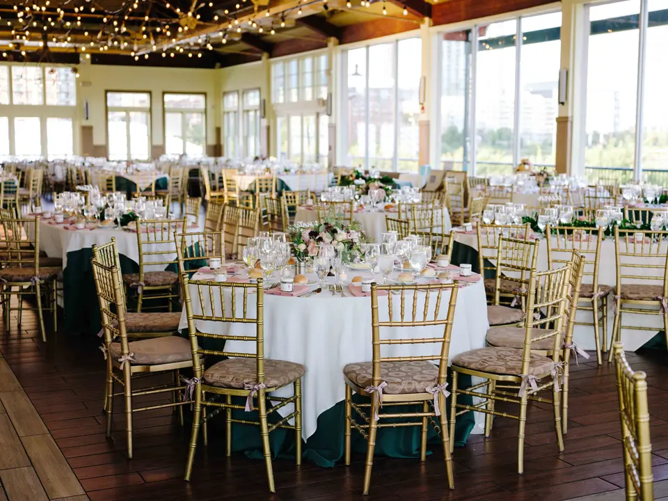 The glass-walled reception room at Liberty House, round tables beneath strings of lights.