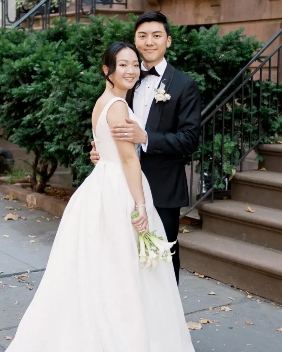 The groom holds the bride close on a brownstone stoop in Brooklyn Heights.