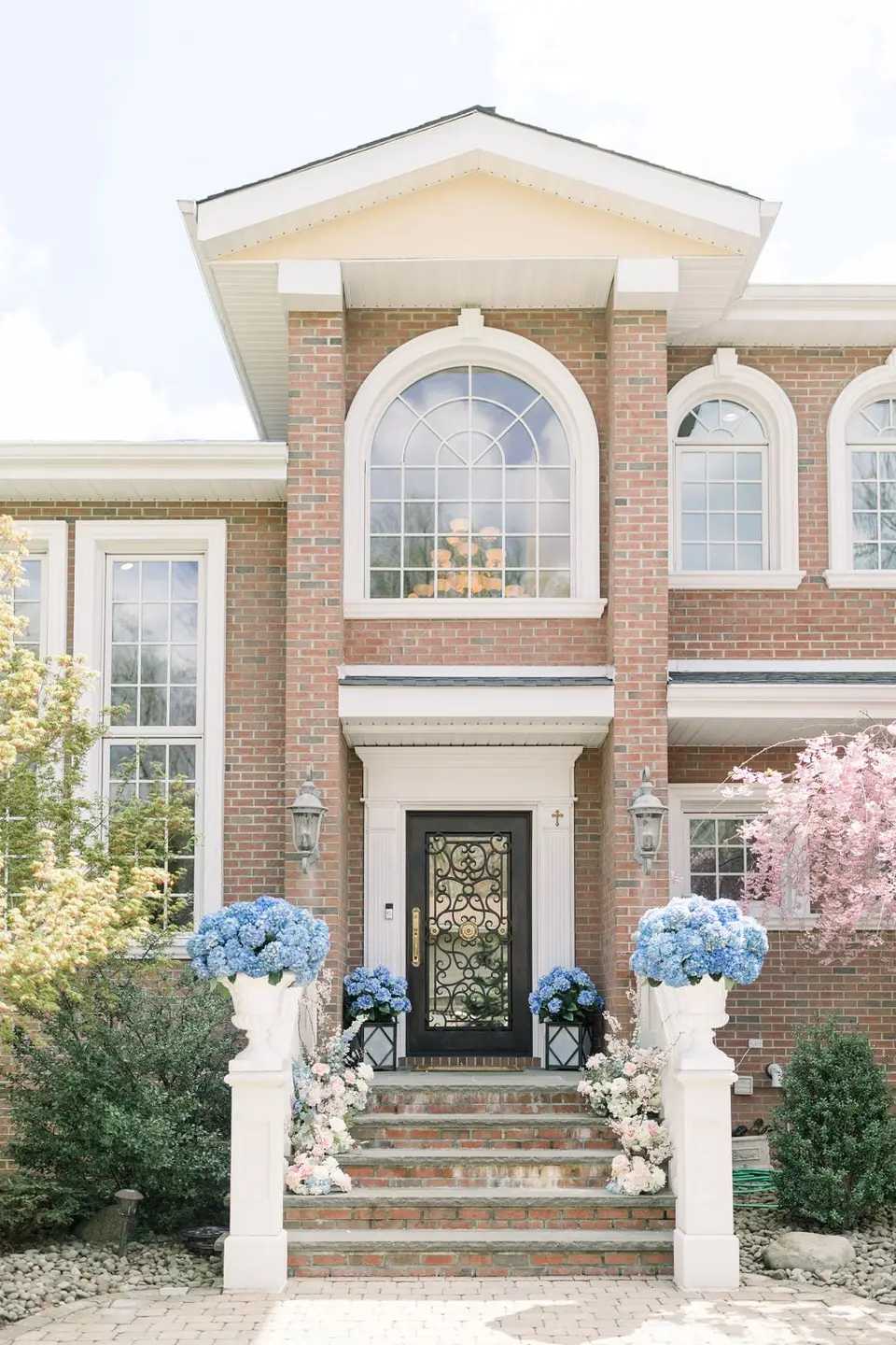 The family home, blue hydrangeas and flowers lining the front steps.