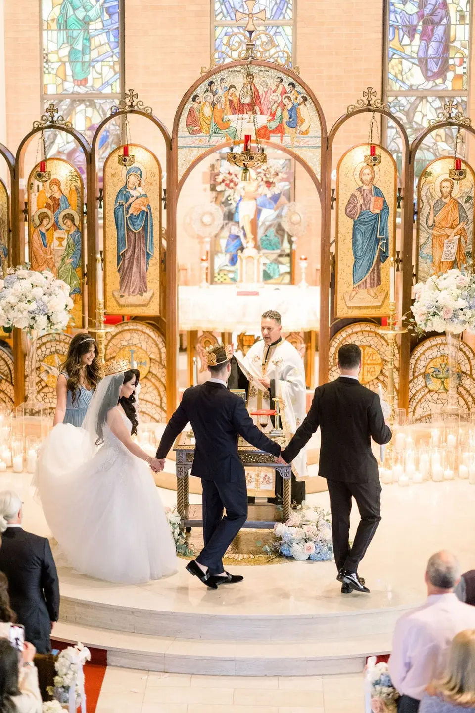 Led by the priest, the bride and groom walk around the altar table, hands joined with a groomsman.