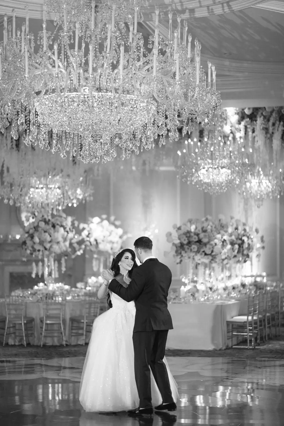 The first dance beneath a great crystal chandelier. Black and white.