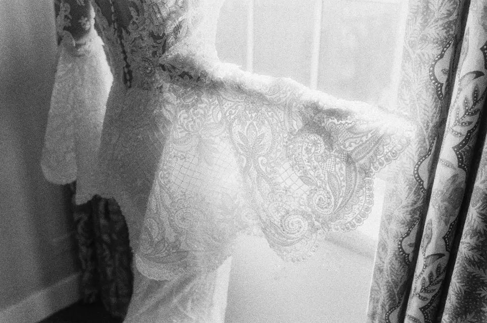 The lace sleeve of the gown against the light of a window. Black and white.