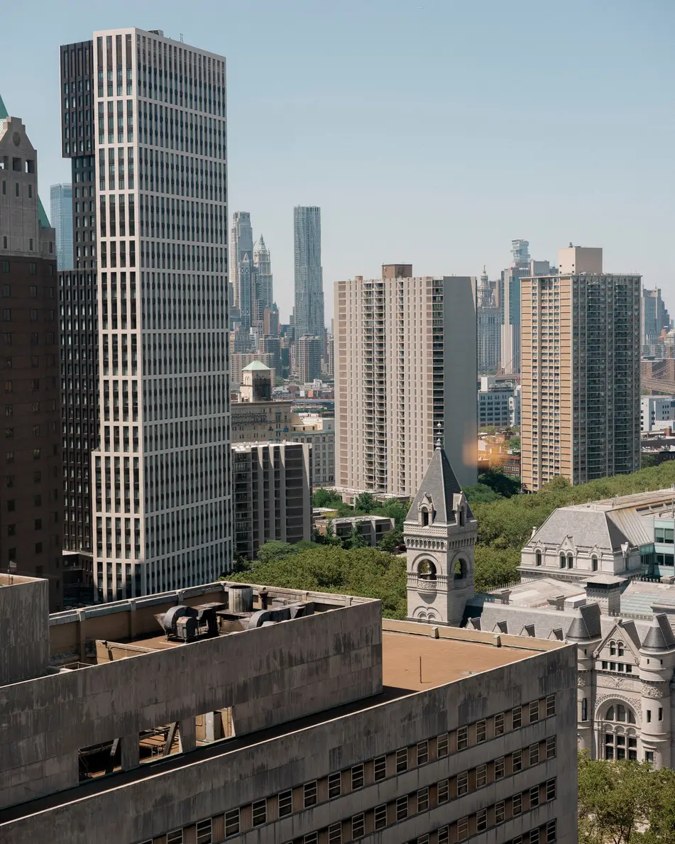The view from the suite: Brooklyn towers, green treetops and a church spire in the morning light.