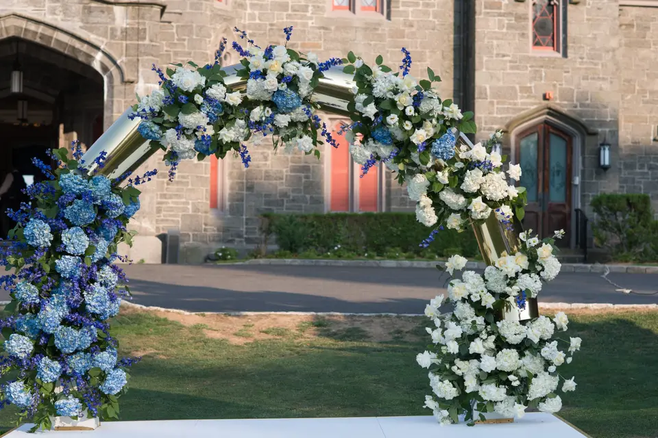 The arch of blue and white flowers before the castle's stone doorway.