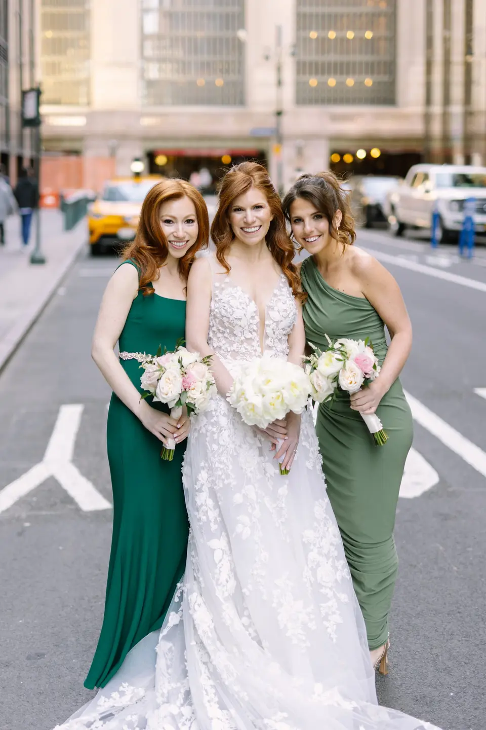 The bride between two bridesmaids in green on Vanderbilt Avenue.