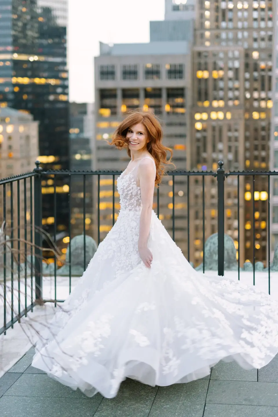The bride twirls on the roof terrace, lit Midtown towers behind her.